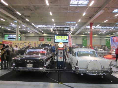 1991 Ford LTD Crown Victoria - Classic cars and a vintage gas pump on display at an indoor event.