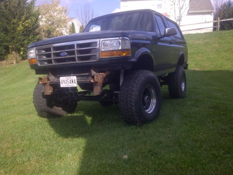 1995 Ford Bronco - This modified Ford Bronco features a significant lift kit and large off-road tires, giving it an aggressive stance.