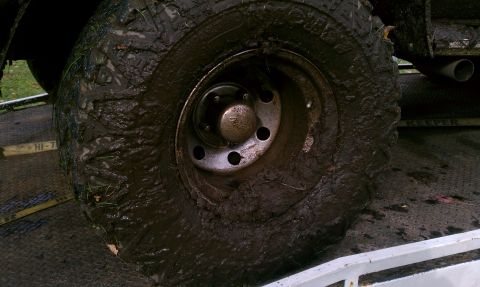 1979 Ford Bronco - A vehicle's tire and exhaust pipe are heavily coated in mud, suggesting off-road use.