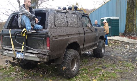 1979 Ford Bronco - This mud-splattered SUV, likely a 1978 model, is viewed from the rear with a person seated in its open tailgate.