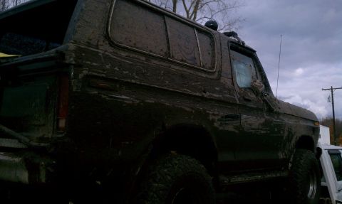 1979 Ford Bronco - Mud-covered 1978 Ford Bronco seen from the side and front quarter angle.