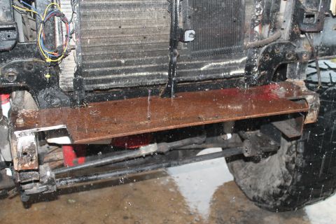 1990 Ford Bronco - Custom metal bracket is attached to the front of a vehicle, obscuring the radiator and suspension components.