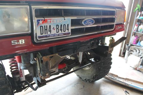 1990 Ford Bronco - The front grille and bumper of a red Ford Bronco, showing a Texas license plate and '5.8' badging.