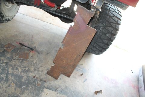 1990 Ford Bronco - Metal plates are being attached to the rear axle and tire of a vehicle.
