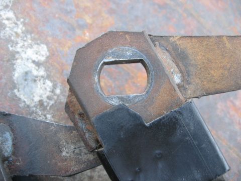 1981 Ford Bronco - This close-up shows a rusty metal bracket with a distinct hexagonal hole, likely a component from a vehicle's mechanical system.