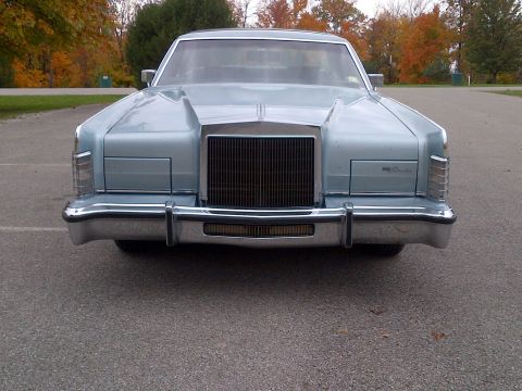 2001 Ford Crown Victoria - Front view of a light blue Lincoln Continental parked outdoors with autumn trees in the background.