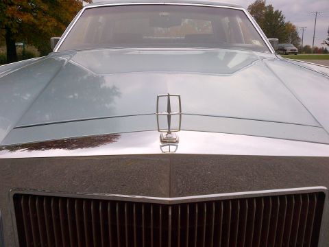 2001 Ford Crown Victoria - The hood ornament and grille of a classic Lincoln Continental are visible in this front-facing shot.