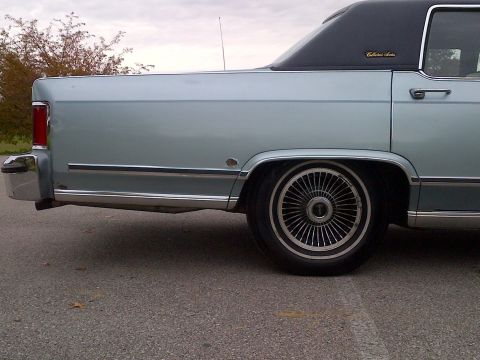 2001 Ford Crown Victoria - Rear side view of a light blue Lincoln Continental with a black vinyl roof and chrome accents.