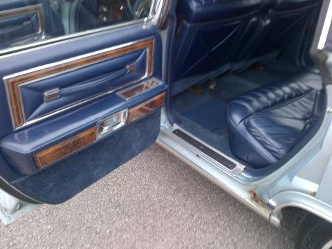 2001 Ford Crown Victoria - The interior features blue leather seats and door panels accented with wood trim.