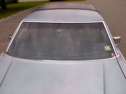 2001 Ford Crown Victoria - The front of a vintage sedan is shown from a high angle, focusing on the windshield and hood area.