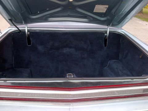 2001 Ford Crown Victoria - The spacious trunk of this vehicle is lined with dark blue carpet and features chrome accents on the rear trim.