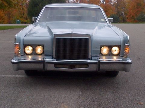 2001 Ford Crown Victoria - This Lincoln Continental Mark V is shown from the front with its headlights illuminated.
