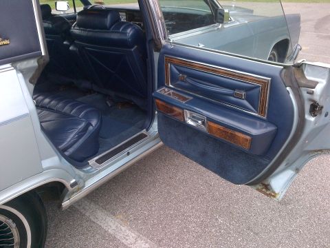2001 Ford Crown Victoria - Interior view of a Lincoln Continental, showing blue leather seats and wood trim. Another vehicle is visible in the background.