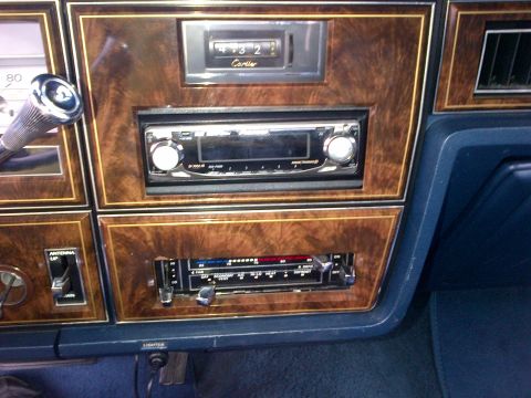 2001 Ford Crown Victoria - The dashboard features wood grain trim, an aftermarket stereo, and climate controls, with a 'Cartier' label visible on the clock.