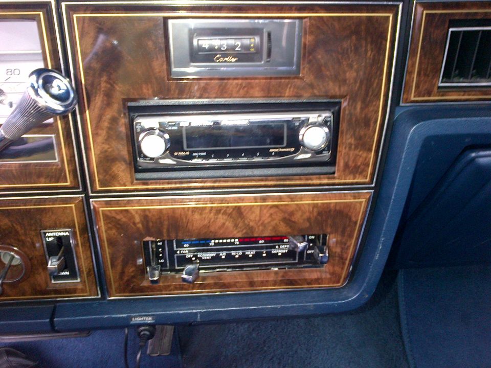 Interior dashboard with wood grain trim, aftermarket stereo, and climate controls