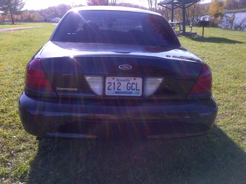 2001 Ford Crown Victoria - Rear view of a black Ford Crown Victoria Police Interceptor parked outdoors on a grassy area.
