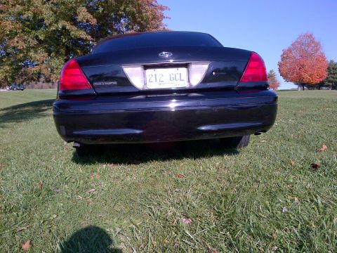 2001 Ford Crown Victoria - Rear view of a black 2001 Ford Crown Victoria parked outdoors on a grassy area.