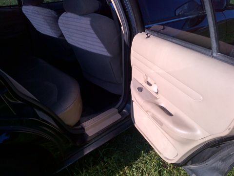 2001 Ford Crown Victoria - The interior of a car is shown, focusing on the door panel and the rear seating area.