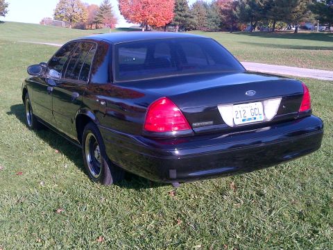 2001 Ford Crown Victoria - Rear view of a black 2001 Ford Crown Victoria with tinted windows and a license plate.