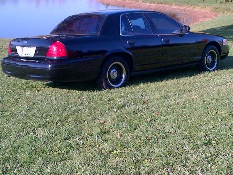 2001 Ford Crown Victoria - Black 2001 Ford Crown Victoria parked on a grassy area next to a body of water.