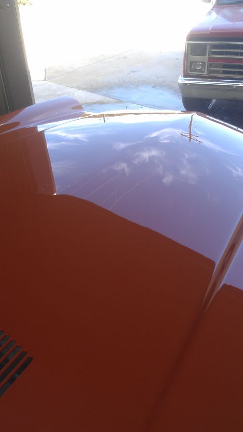 1973 Chevrolet Camaro - The reflection on the hood of a red car shows clouds and the front of a red truck. The registry claims this is a 1973 Chevrolet Camaro, but…