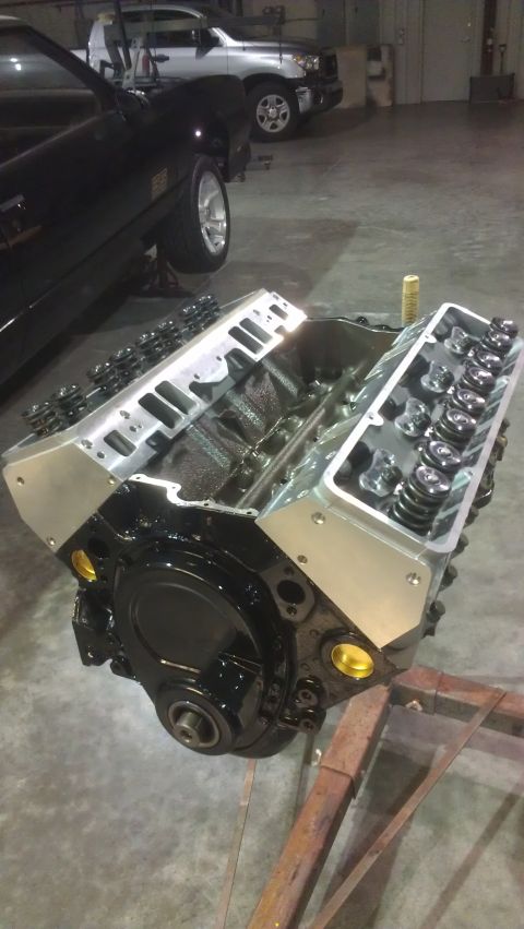 1973 Chevrolet Camaro - V8 engine block with aluminum valve covers and exposed pushrods, resting on a stand.