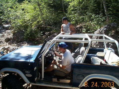 1977 Ford Bronco - A 1977 Ford Bronco navigates a challenging rocky trail with two occupants.