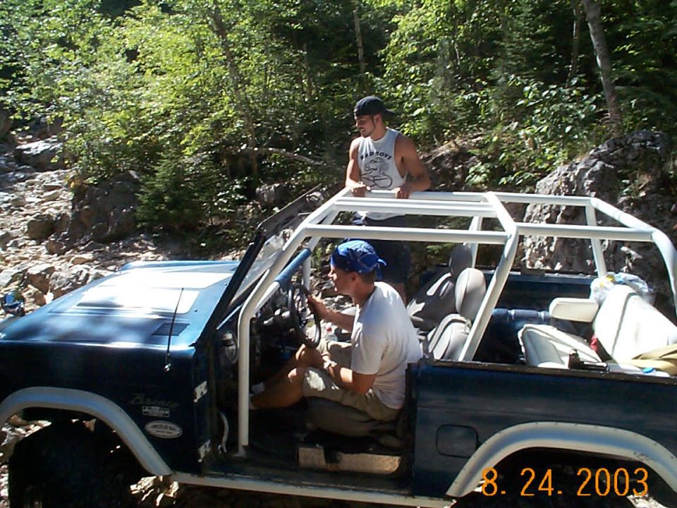 1977 Ford Bronco with white roll cage on rocky trail
