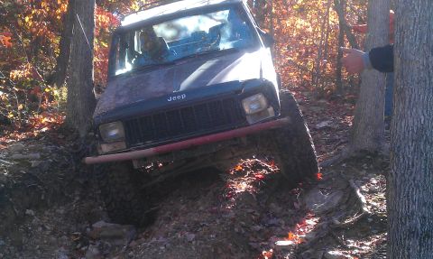 1987 Ford Bronco - This Jeep is navigating a challenging off-road path with steep inclines and obstacles.