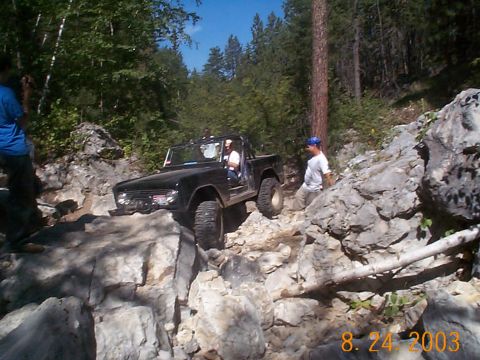 1977 Ford Bronco - Ford Bronco tackling a challenging off-road course with steep inclines and large rocks.