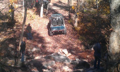 1987 Ford Bronco - Off-road vehicles navigate a challenging trail during an autumn outing.