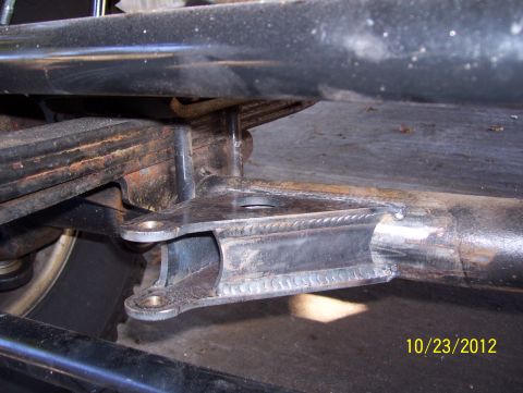 1990 Ford Bronco - A close-up view of a vehicle's suspension components, showing a leaf spring and a welded bracket.