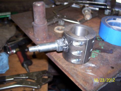 1990 Ford Bronco - A close-up view of a metal component, possibly for a vehicle, on a workbench with tools.