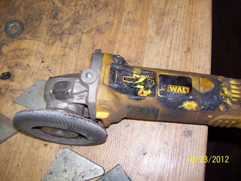 1990 Ford Bronco - A DeWalt angle grinder sits on a workbench, showing signs of wear and tear.