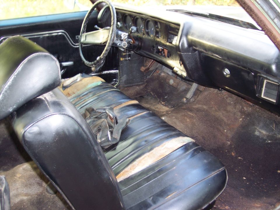 Interior of a 1970 Chevrolet Chevelle showing worn seats, dashboard, and steering wheel