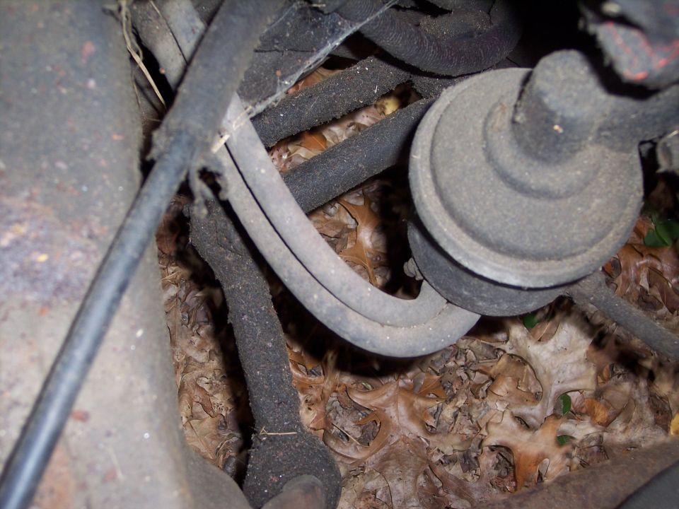 Close-up of engine wiring harness and fuel filter assembly with debris on the ground