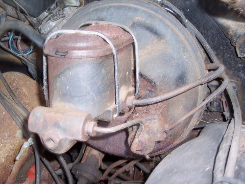 1970 Chevrolet Chevelle - Close-up of a corroded brake booster and master cylinder assembly, showing brake lines and wiring.