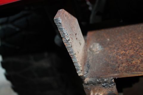1990 Ford Bronco - A close-up view shows a crudely welded metal bracket, possibly part of a custom bumper modification.