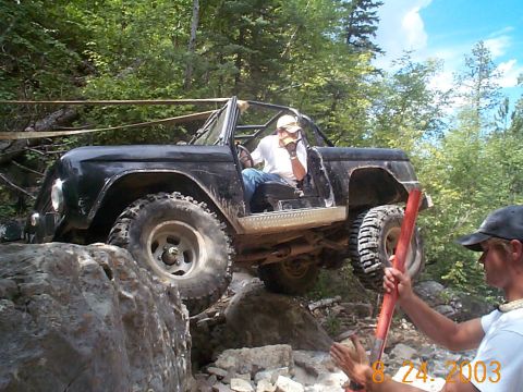 1977 Ford Bronco - 1977 Ford Bronco navigating a rocky trail with assistance from a spotter.