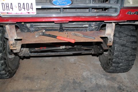 1990 Ford Bronco - Custom bumper fabrication in progress on a Ford truck, with tools laid out on the metal plate.