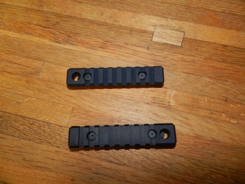 1996 Ford Bronco - Two black Picatinny rails are shown on a wooden surface, with a Supermotors.net watermark at the bottom right.