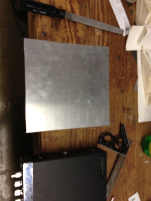 1979 Ford Bronco - A metal sheet, a file, and a speed square are laid out on a wooden workbench, with a watermark for SuperMotors.net visible.