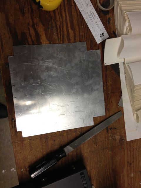 1979 Ford Bronco - Metal sheet and tools laid out on a workbench, possibly for fabrication.