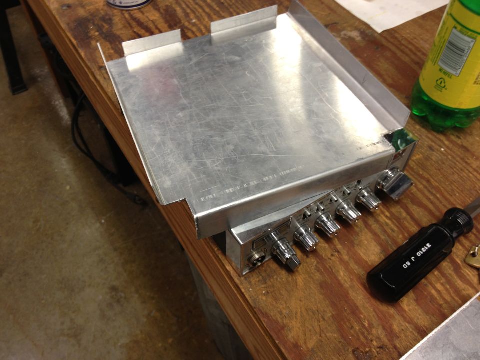 CB radio with knobs and a screwdriver on a wooden table