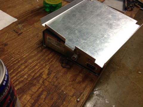 1979 Ford Bronco - An electronic device with a metal casing and various connectors is placed on a wooden table.