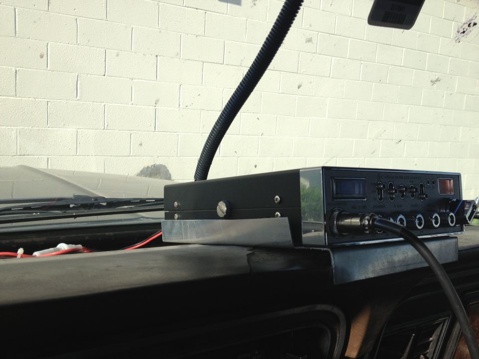 CB radio mounted on dashboard with a flexible antenna cable
