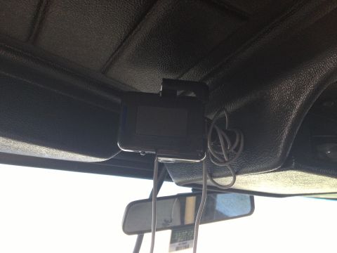 1979 Ford Bronco - An aftermarket device is mounted to the interior roof of the vehicle, with wires dangling down.