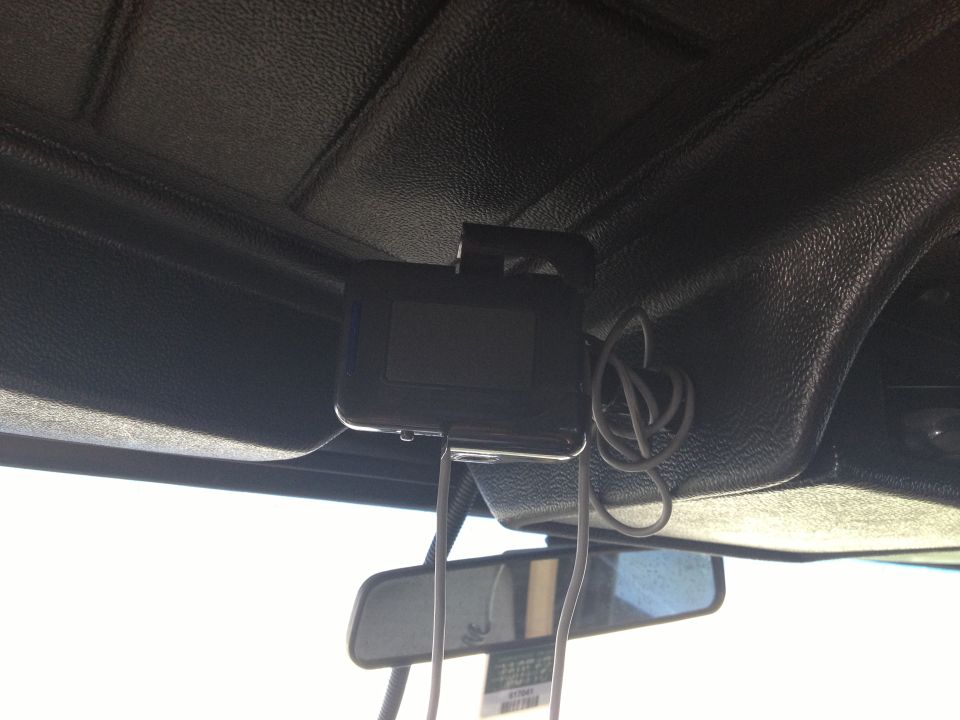 device with wires hanging from roof liner above rearview mirror