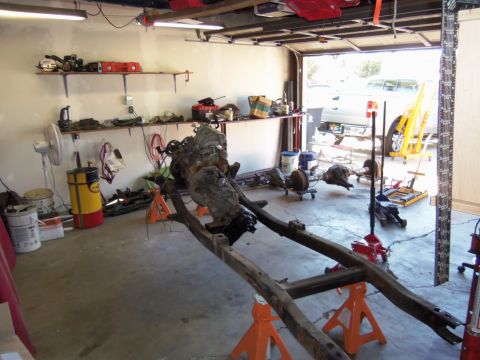 1968 Ford Bronco - A vehicle's chassis, engine, and transmission are disassembled and supported by jack stands in a garage setting.