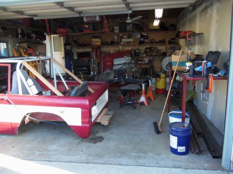 1968 Ford Bronco - The body of a 1968 Ford Bronco is staged in a cluttered garage, awaiting restoration or modification.